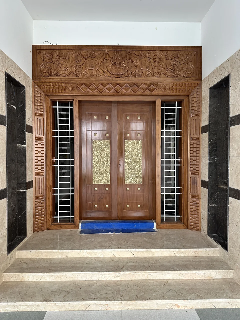 Detailed carved timber entrance door framed by a sheltered porch